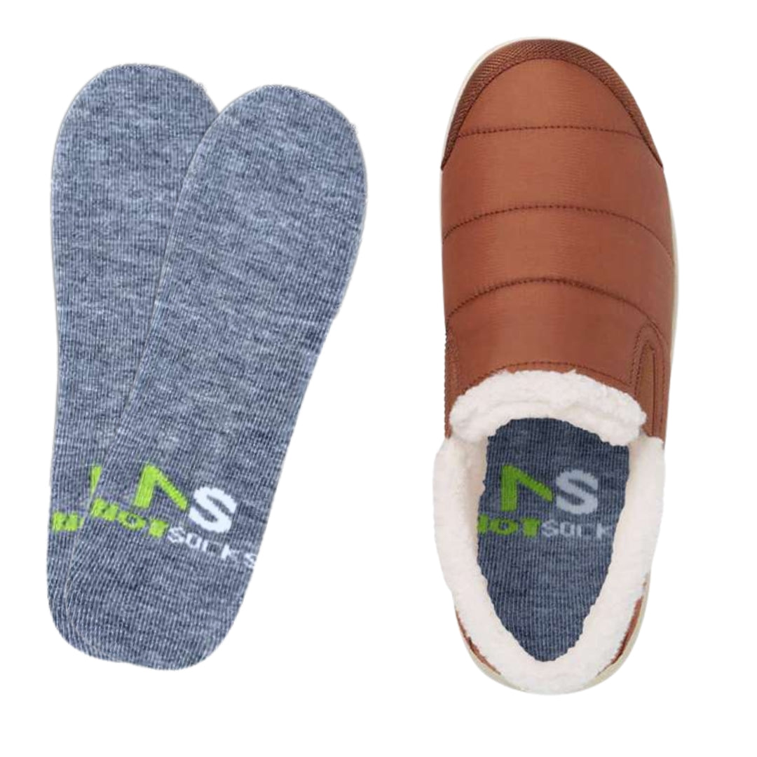 NotSocks branded gray no-show insole socks displayed with brown quilted shearling slippers: two flat insoles on left with "NAS NotSocks" green logo, one inserted visibly inside the open shoe on right.